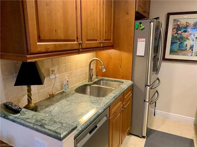 a kitchen with stainless steel appliances granite countertop a sink refrigerator and microwave
