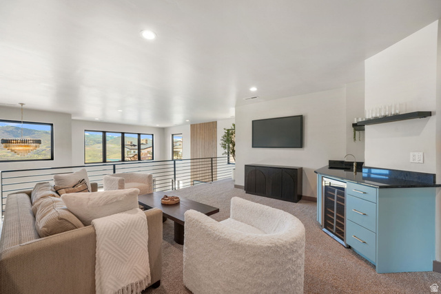 10646 North Reflection Ridge Hideout, UT 84036 - Photo 18 of 43 Spacious loft area featuring a built-in wet bar with a beverage cooler, dark countertop, and light blue cabinetry