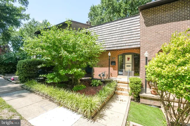 a front view of a house with a yard and potted plants
