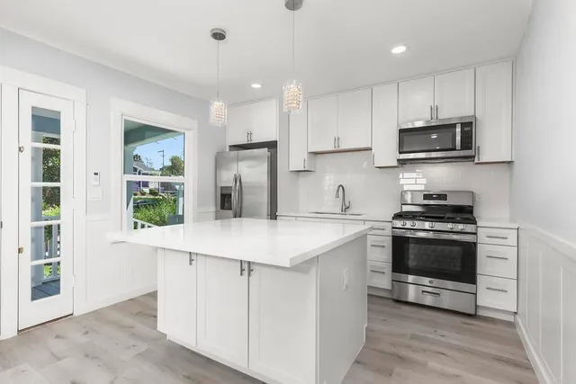 a kitchen with stainless steel appliances granite countertop a stove and a refrigerator