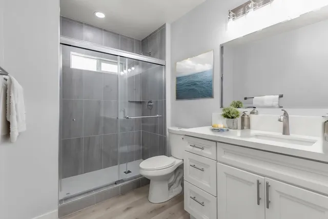 a bathroom with a shower a toilet and a sink