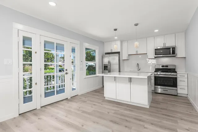 a kitchen with white cabinets and appliances
