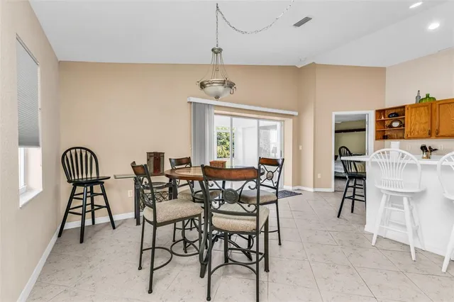 a kitchen with stainless steel appliances granite countertop a sink dishwasher a stove a dining table and chairs with wooden floor