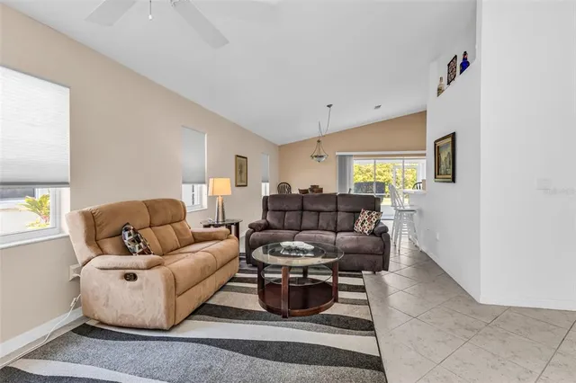 a living room with furniture a flat screen tv and a window