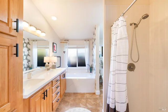 a bathroom with a tub sink and mirror