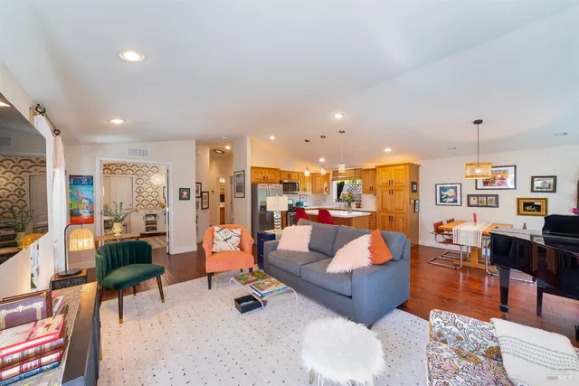 a living room with furniture kitchen view and a large window