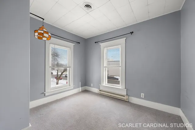 an empty room with windows and ceiling fan
