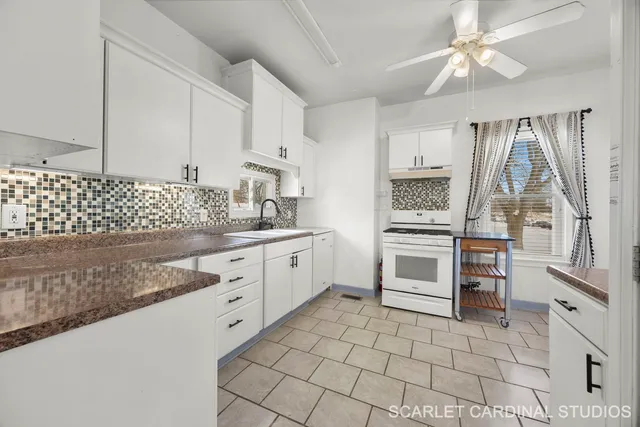 a kitchen with white cabinets and appliances