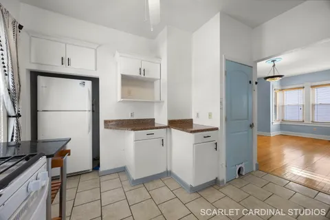 a kitchen with white cabinets and appliances