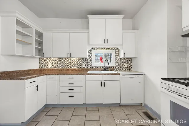 a kitchen with granite countertop white cabinets and white appliances