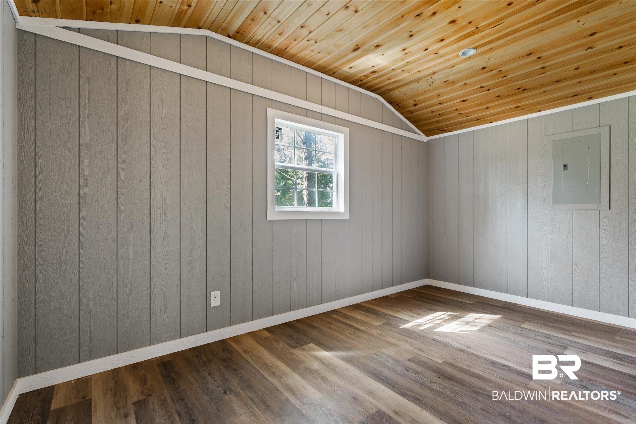 15685 Louis Cooper Road Bay Minette, AL 36507 - Photo 24 of 26 Unfurnished room with hardwood / wood-style floors, wood walls, electric panel, wood ceiling, and lofted ceiling