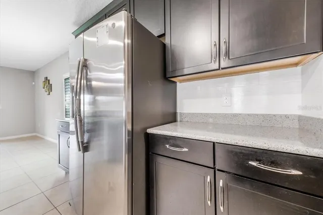 a kitchen with metallic refrigerator and cabinets