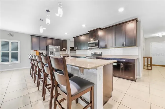 a kitchen with kitchen island a cabinets a counter top space and stainless steel appliances