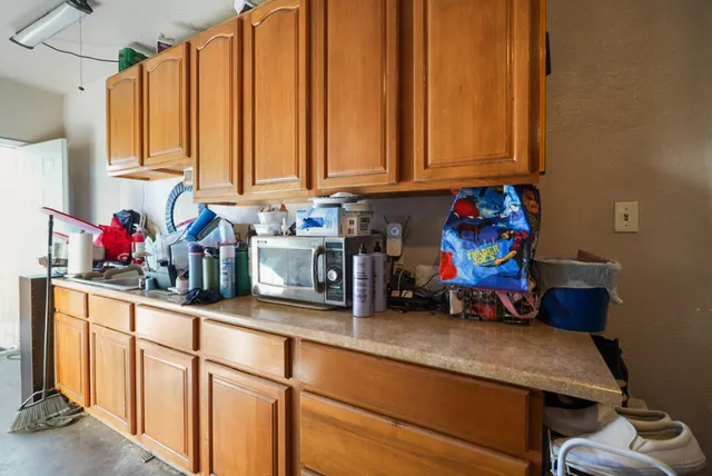 a room with stainless steel appliances furniture cabinets and a window
