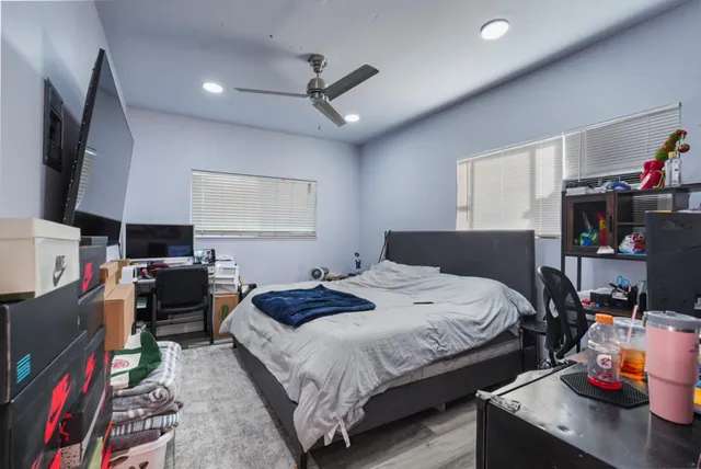 a bedroom with a bed a dresser and a flat screen tv