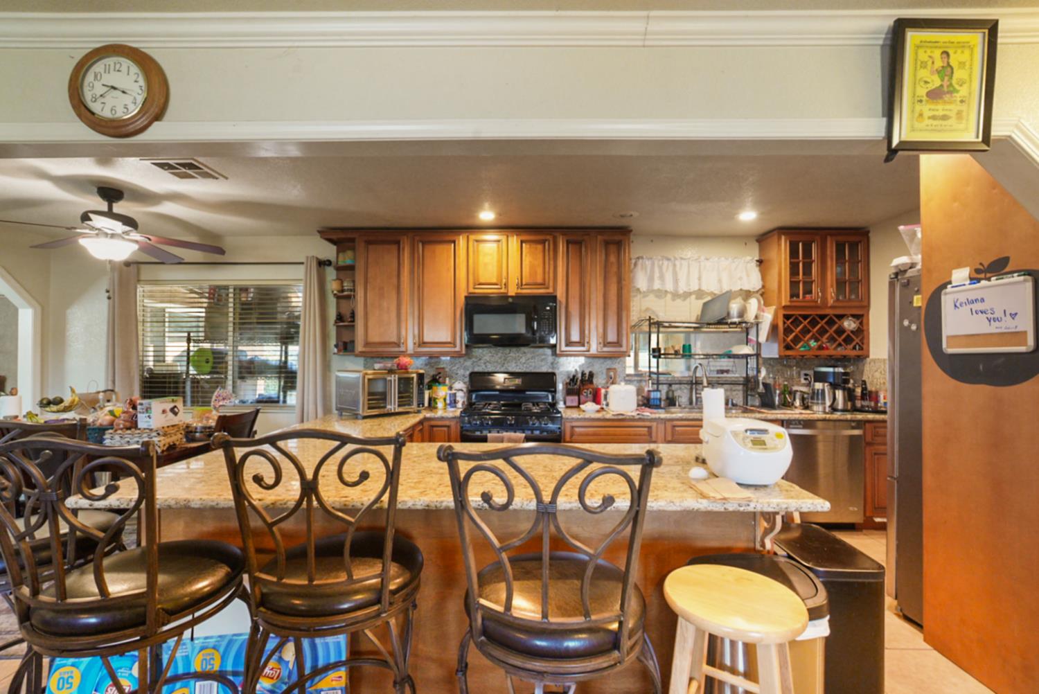 561 Church Street Modesto, CA 95357 - Photo 8 of 38 a kitchen with stainless steel appliances granite countertop a stove top oven a dining table and chairs with wooden floor
