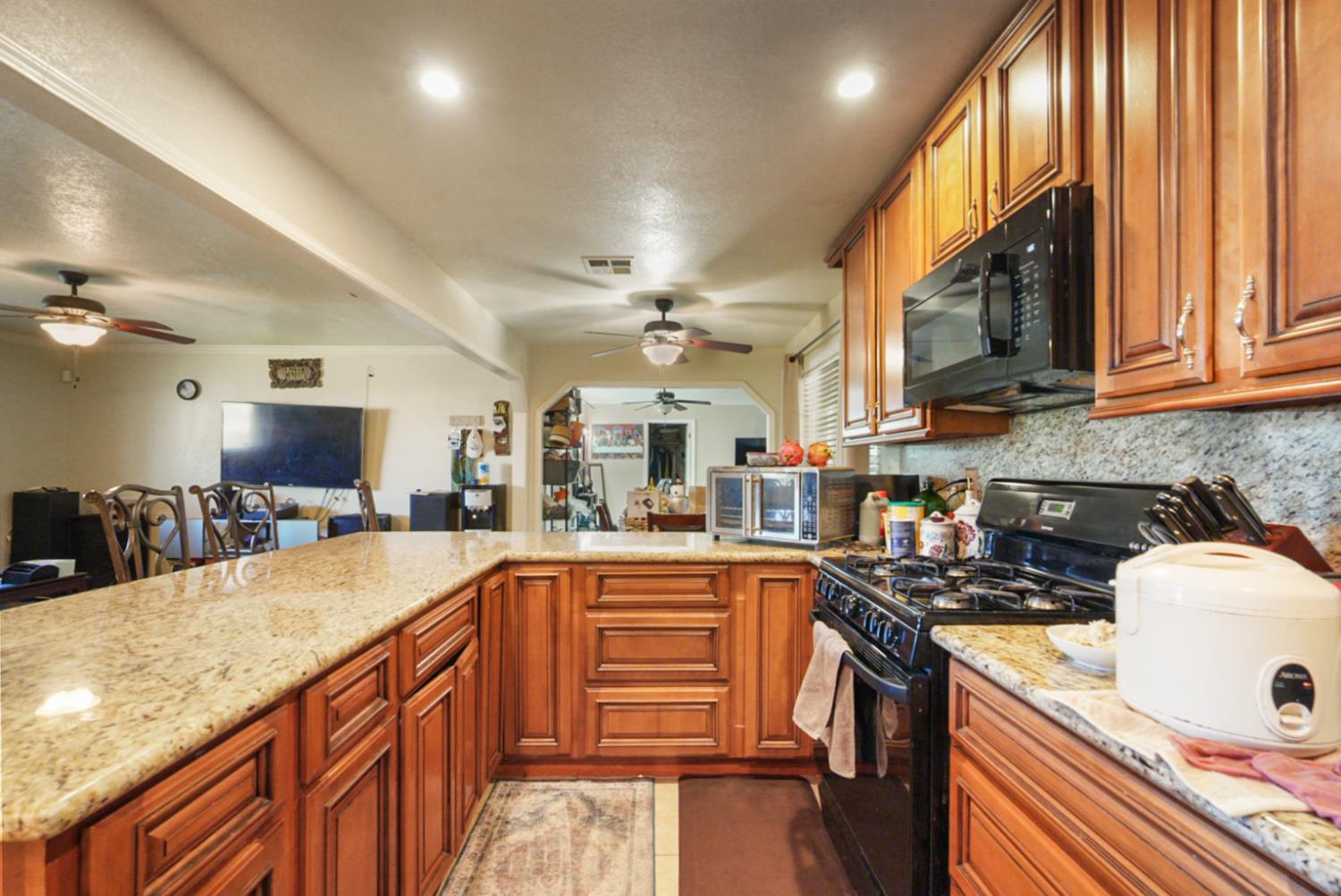 561 Church Street Modesto, CA 95357 - Photo 9 of 38 a kitchen with granite countertop a sink stove and cabinets