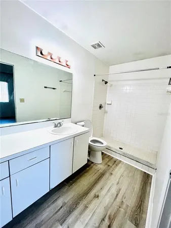 a bathroom with a double vanity sink toilet mirror and bathtub