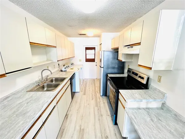 a kitchen with stainless steel appliances granite countertop a sink and a stove