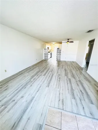 a view of empty room with wooden floor