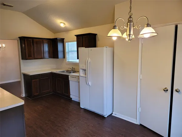 a kitchen with stainless steel appliances a refrigerator and a chandelier