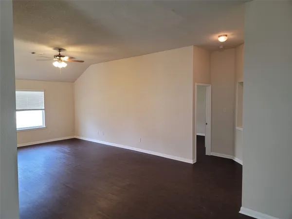 a view of empty room with a ceiling fan and hardwood floor