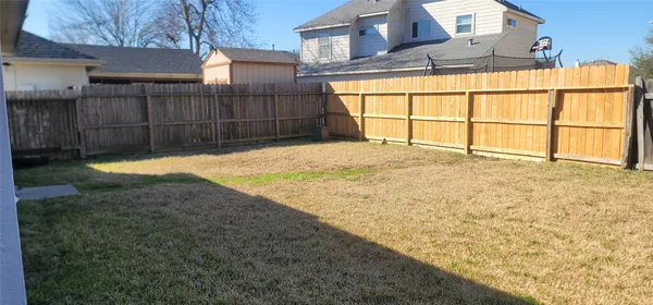 a view of an house with backyard and wooden fence