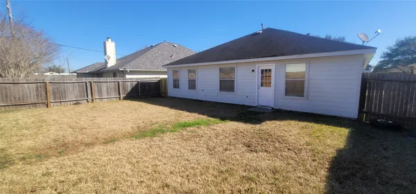 a view of a house with wooden fence
