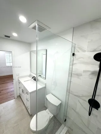 a bathroom with a double vanity sink toilet and shower