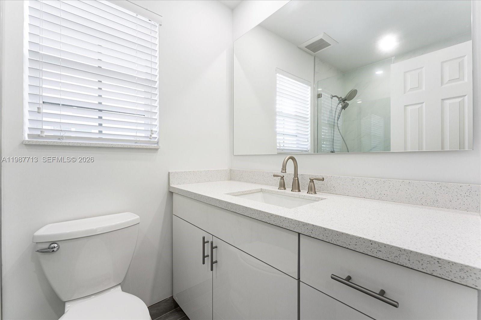 3619 South Le Jeune Road, Unit 1 Coral Gables, FL 33134 - Photo 14 of 17 a bathroom with a toilet sink and mirror