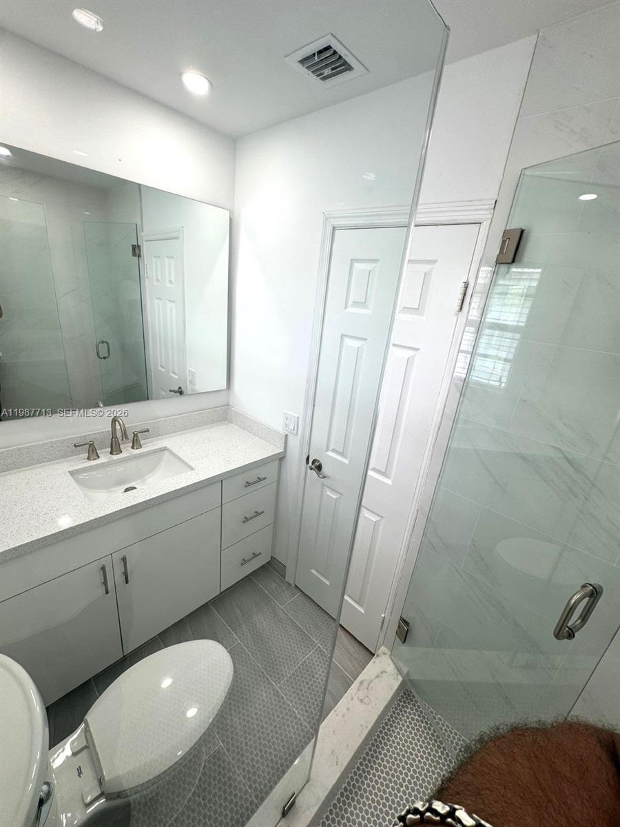 3619 South Le Jeune Road, Unit 1 Coral Gables, FL 33134 - Photo 15 of 17 a spacious bathroom with a double vanity sink a toilet and a mirror