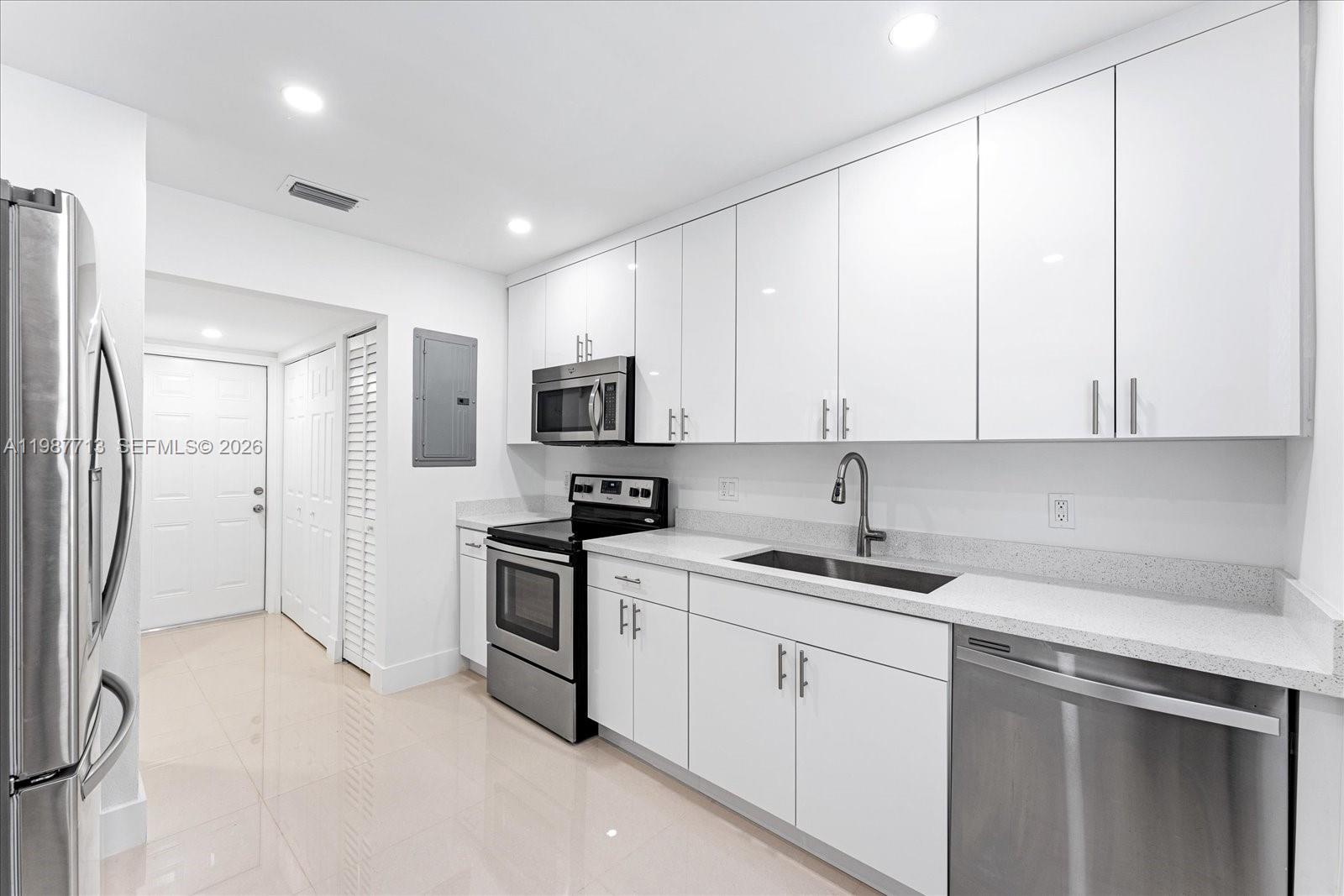 3619 South Le Jeune Road, Unit 1 Coral Gables, FL 33134 - Photo 6 of 17 a kitchen with white cabinets sink and stainless steel appliances