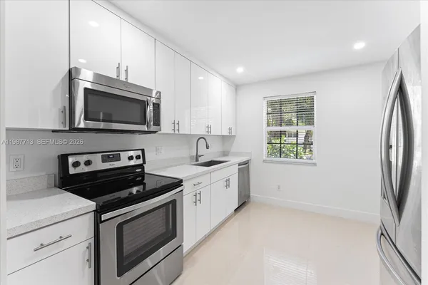 a kitchen with stainless steel appliances a stove microwave and sink