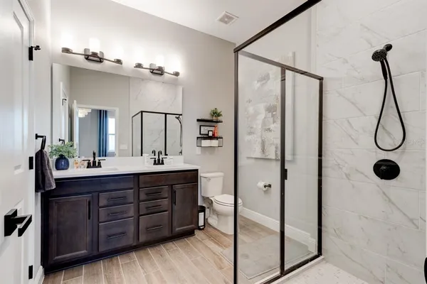 a bathroom with a double vanity sink mirror and shower