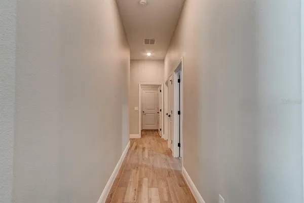 a view of a hallway with wooden floor and a hallway