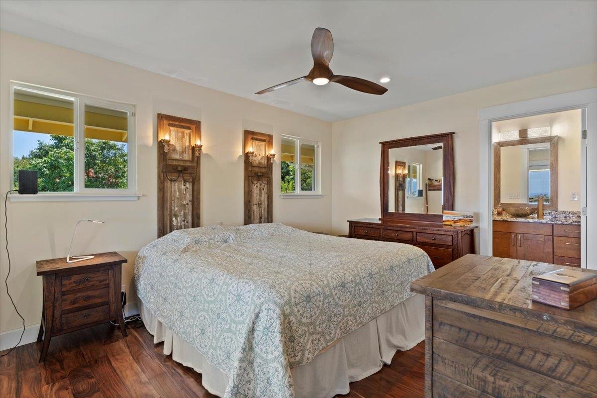 139 Pauwela Road Haiku, HI 96708 - Photo 16 of 42 a bedroom with a bed and wooden floor