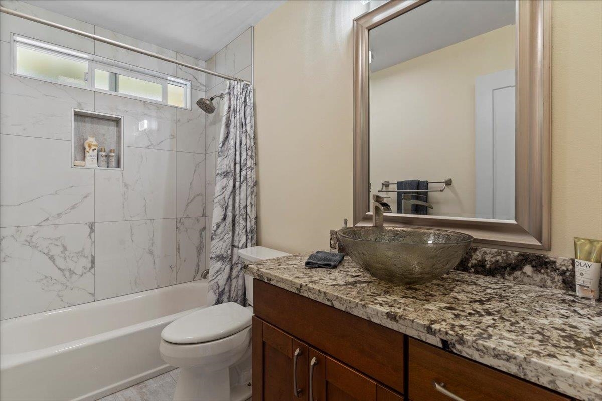 139 Pauwela Road Haiku, HI 96708 - Photo 19 of 42 a bathroom with a granite countertop sink toilet and shower