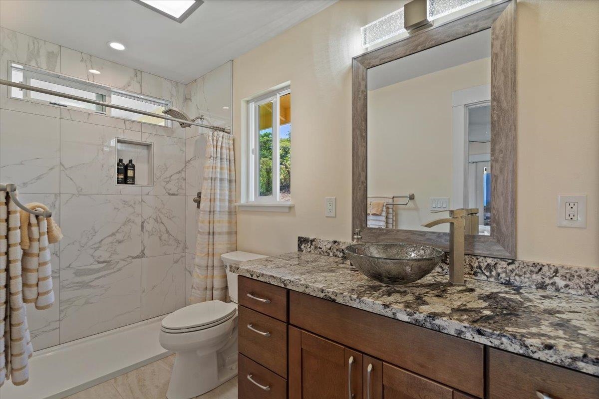 139 Pauwela Road Haiku, HI 96708 - Photo 22 of 42 a bathroom with a granite countertop sink toilet and shower