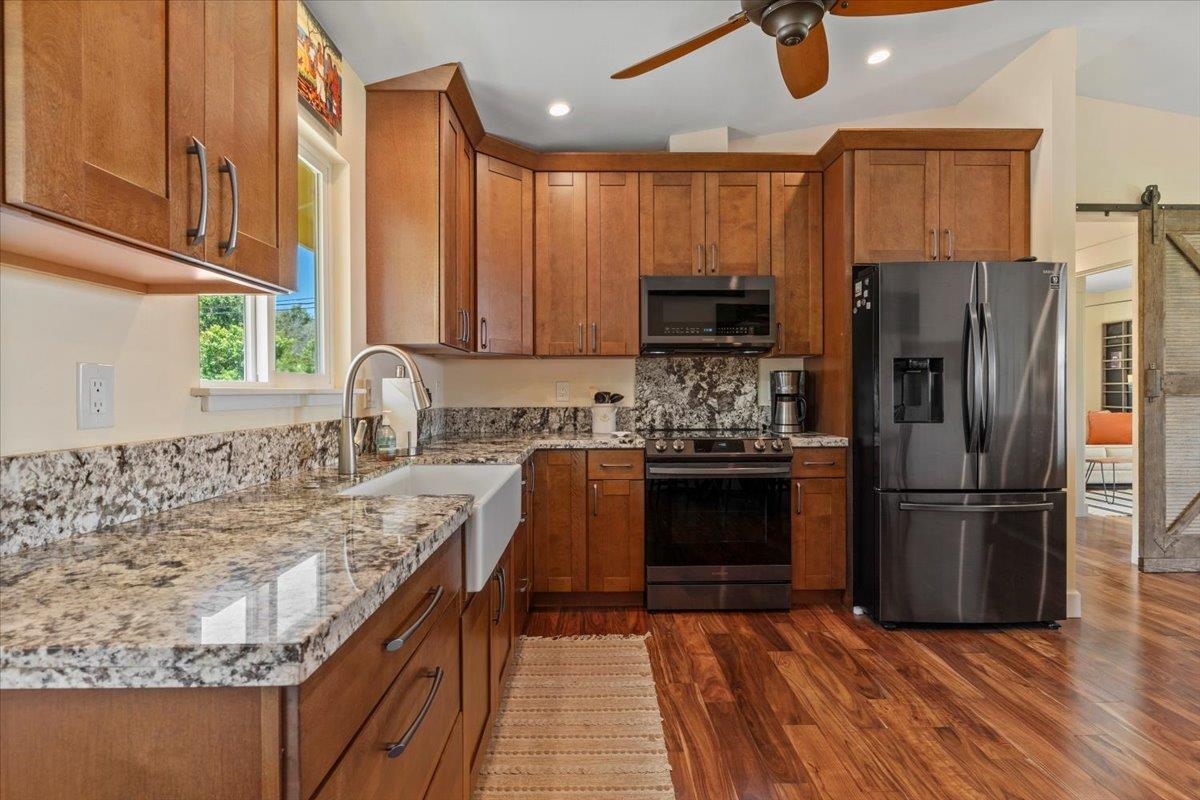 139 Pauwela Road Haiku, HI 96708 - Photo 7 of 42 a kitchen with granite countertop a refrigerator stove and microwave