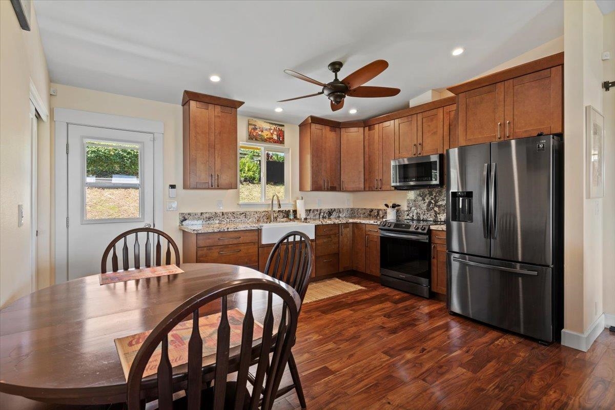 139 Pauwela Road Haiku, HI 96708 - Photo 9 of 42 a kitchen with stainless steel appliances granite countertop a refrigerator a sink a stove a dining table and chairs