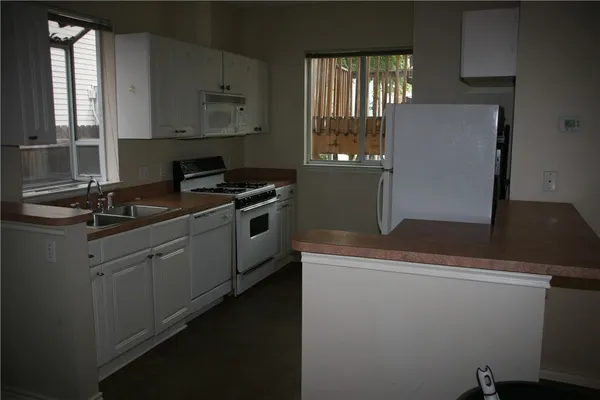 a kitchen with cabinets window and stainless steel appliances