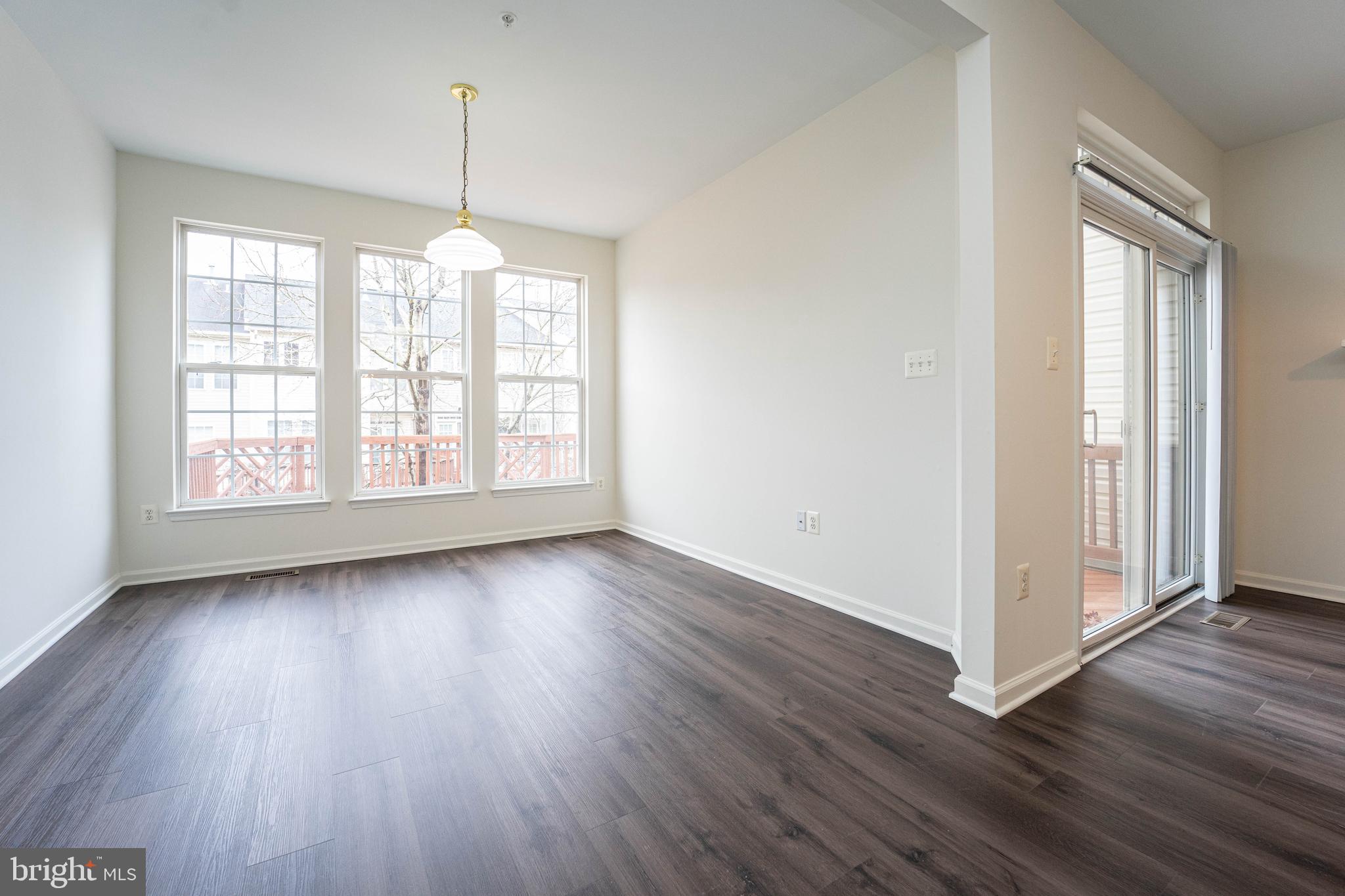 4309 Windflower Way Bowie, MD 20720 - Photo 11 of 46 an empty room with wooden floor and windows