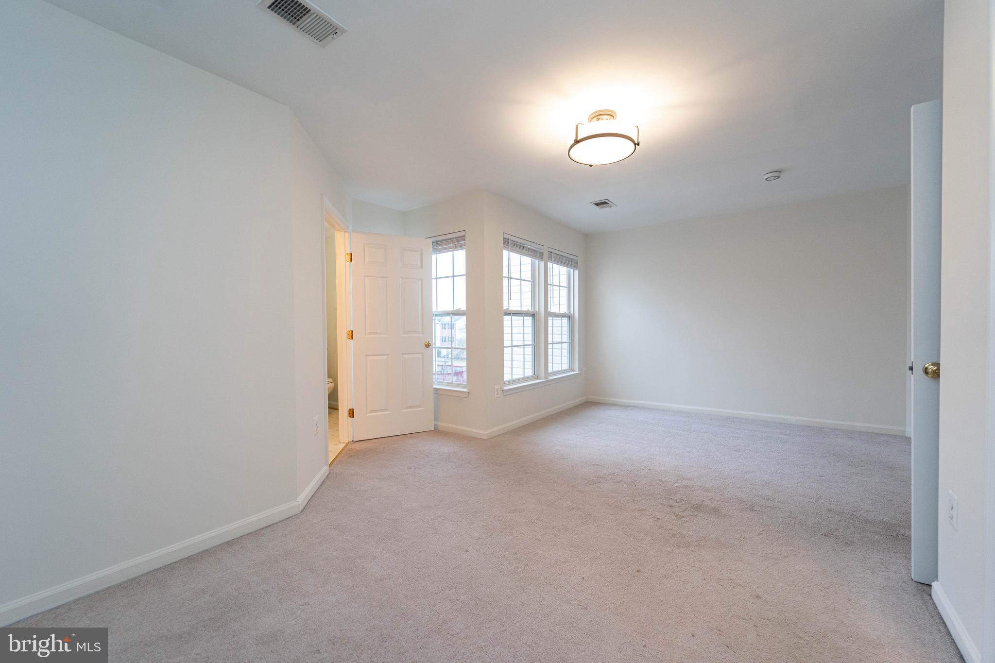 4309 Windflower Way Bowie, MD 20720 - Photo 23 of 46 an empty room with windows and ceiling fan
