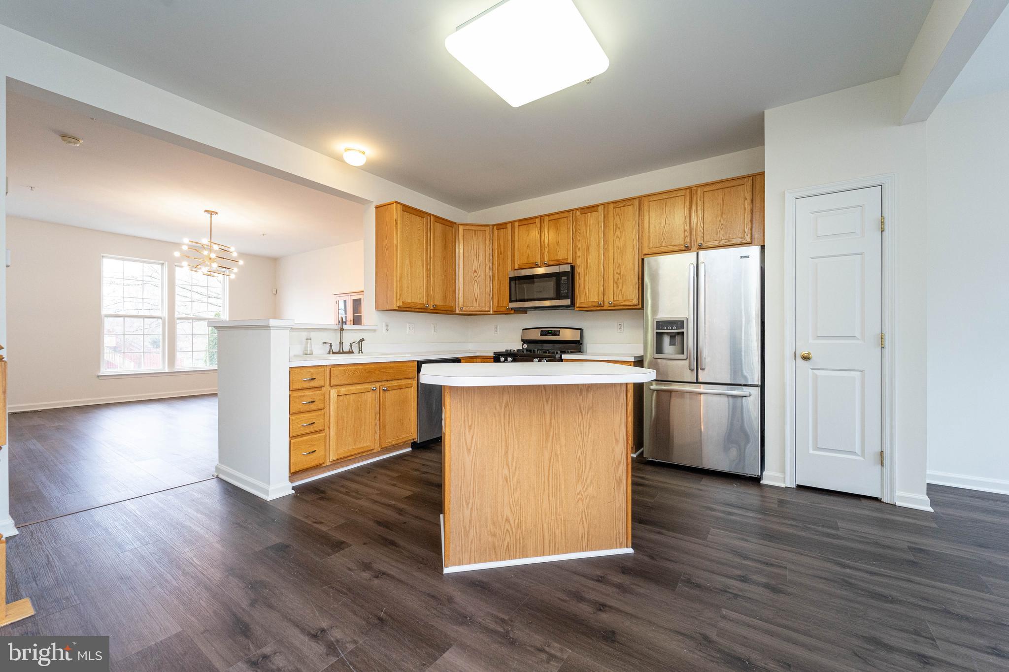 4309 Windflower Way Bowie, MD 20720 - Photo 35 of 46 a kitchen with granite countertop wooden floors stainless steel appliances a sink and a window