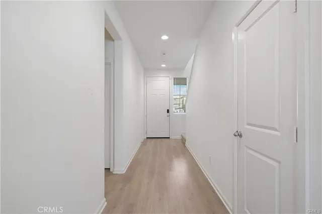 a kitchen with stainless steel appliances granite countertop a stove a sink refrigerator a dining table and chairs with wooden floor