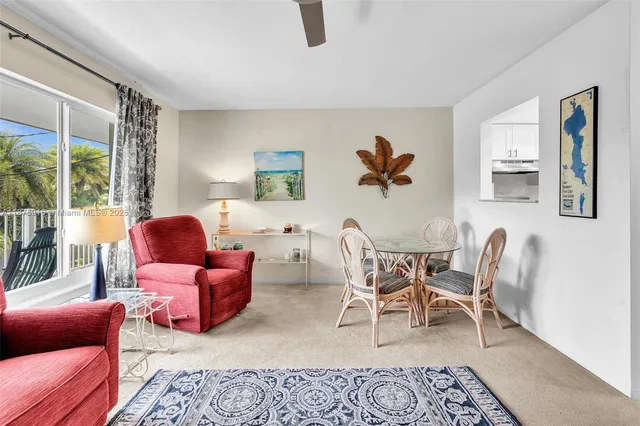 a living room with furniture a rug and a large window
