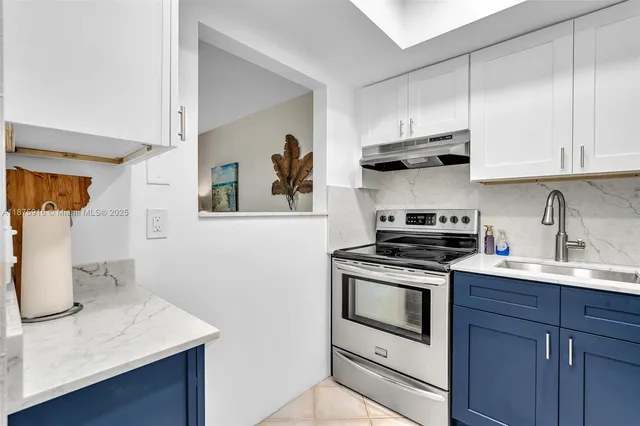 a kitchen with stainless steel appliances a stove a sink and cabinets