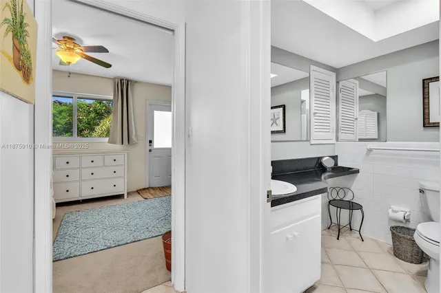 a kitchen with white cabinets and window