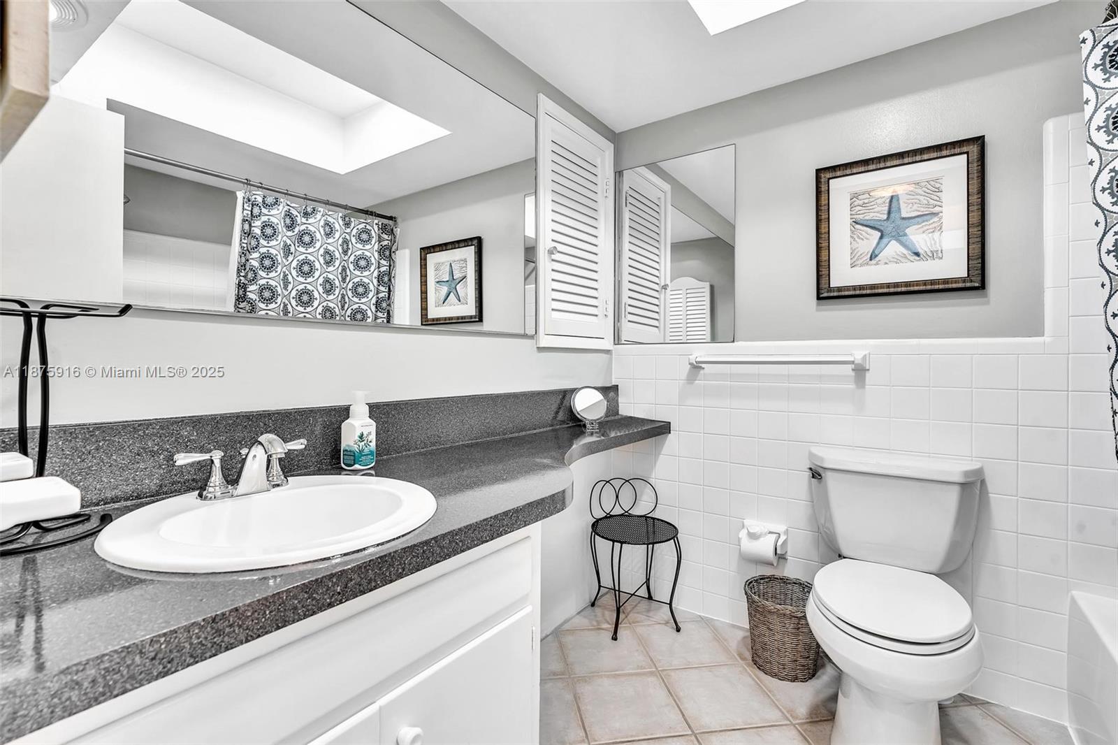 2501 North Ocean Boulevard, Unit 18 Pompano Beach, FL 33062 - Photo 25 of 36 a bathroom with a toilet sink and mirror