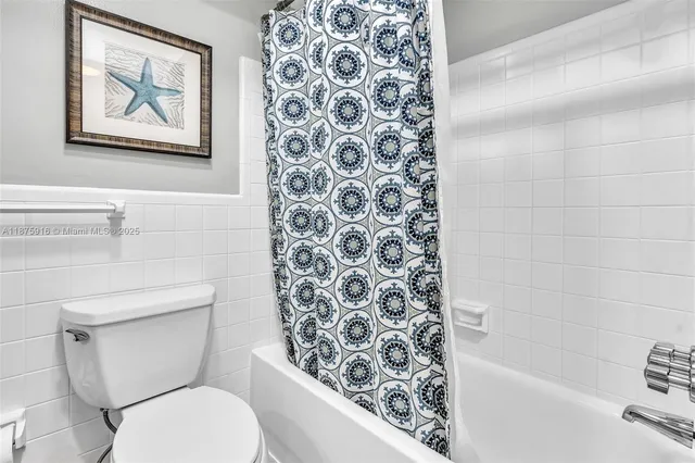 a bathroom with a toilet and a shower curtain